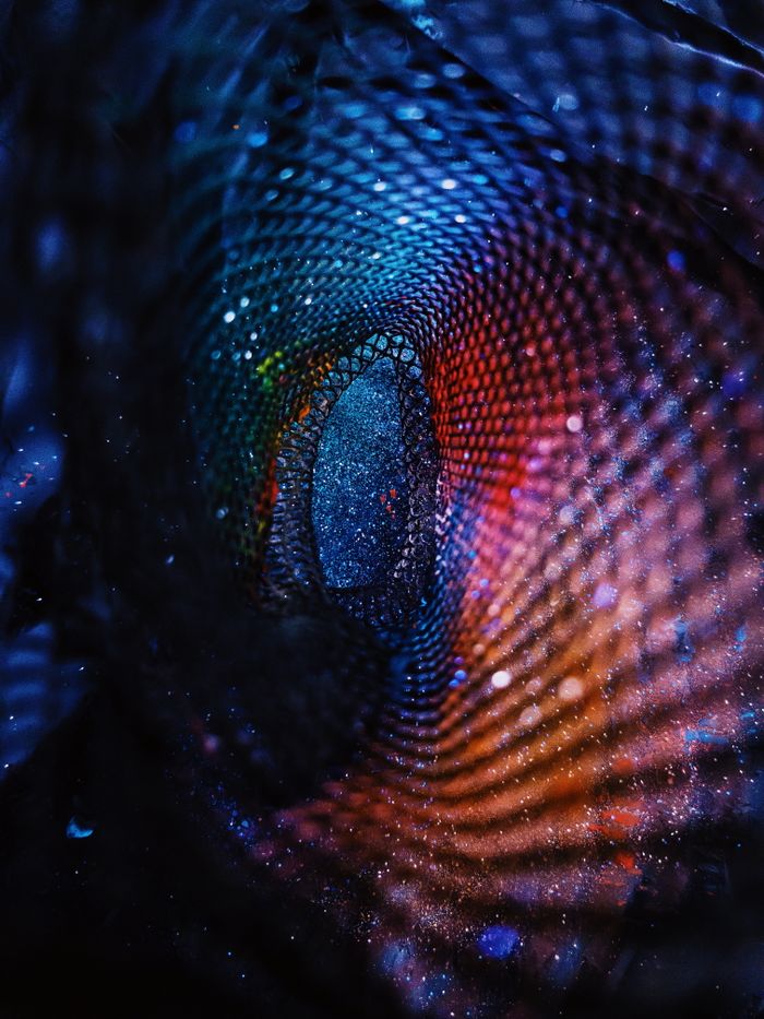 Blurred vibrant holographic swirling ornament with colorful cells and reflections forming night starry pattern
