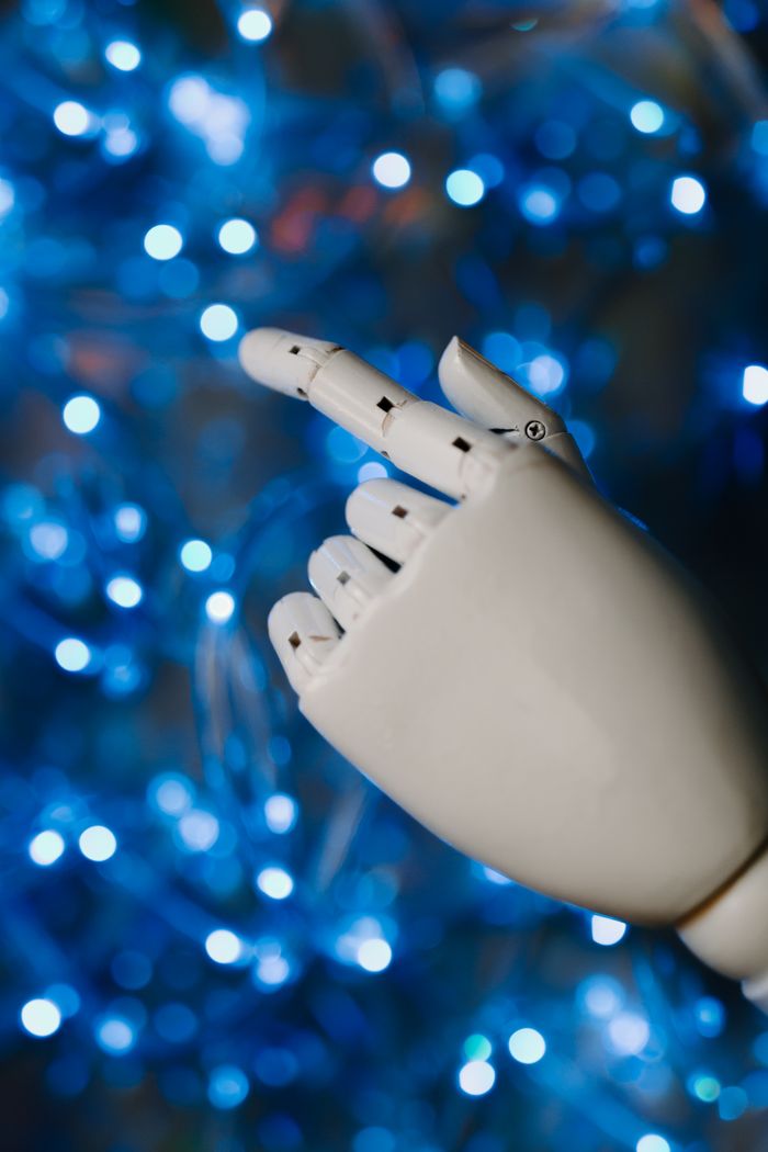 ¿Por qué la gestión de vulnerabilidades es vital para tu empresa en 2026? Close-up of a robotic hand with glowing blue bokeh background, symbolizing advanced technology.